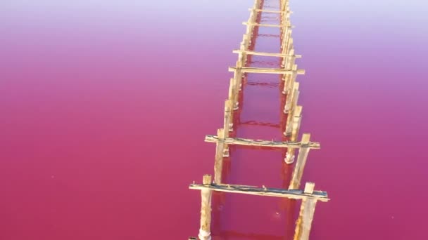 Lago rosado y viejas estructuras de madera. Vista aérea. - Metraje, vídeo