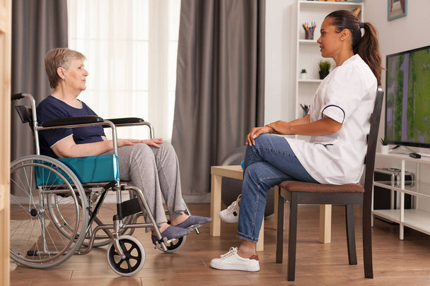 Cuidador conversando com uma mulher com deficiência
 - Foto, Imagem