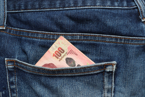 Banconota da cento baht della Thailandia nella tasca posteriore dei jeans. Concetto di risparmio di denaro o finanza. - Foto, immagini