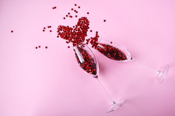 two champagne glasses with confetti in shape of heart isolated on an empty pink festive background, copy space, valentines day holiday festive card - Fotografie, Obrázek