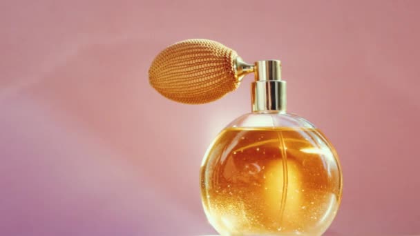 Luksusowa złota butelka perfum i błyszczące lekkie flary na różowym tle, efektowny zapach perfumerii jako produkt perfumeryjny dla marki kosmetycznej i kosmetycznej - Materiał filmowy, wideo