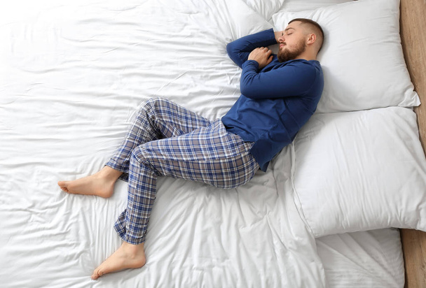 Young man sleeping in bed at home - Φωτογραφία, εικόνα
