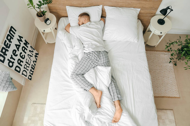Jongeman slaapt thuis in bed - Foto, afbeelding