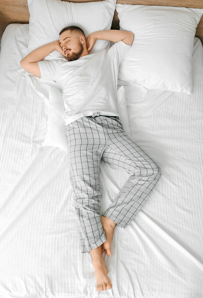 Young man sleeping in bed at home - Valokuva, kuva