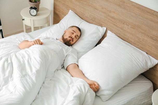 Young man sleeping in bed at home - Фото, зображення