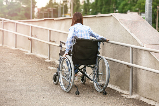 Молодая женщина в инвалидной коляске на открытом воздухе - Фото, изображение