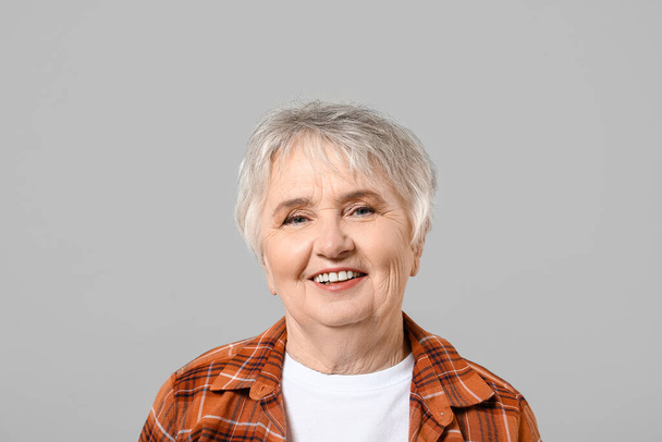 Elegante donna anziana su sfondo grigio - Foto, immagini
