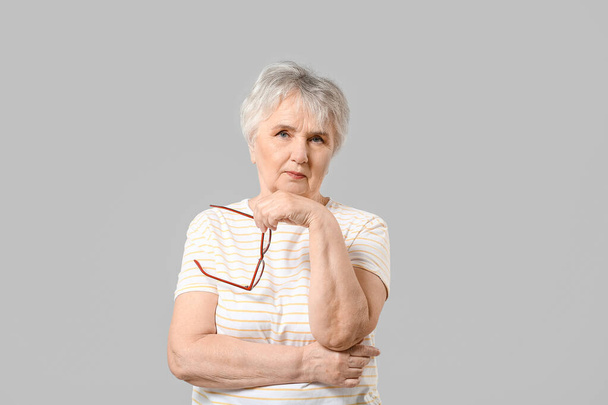 Stilvolle Seniorin auf grauem Hintergrund - Foto, Bild