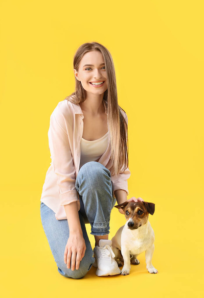 Young woman with cute dog on color background - Zdjęcie, obraz