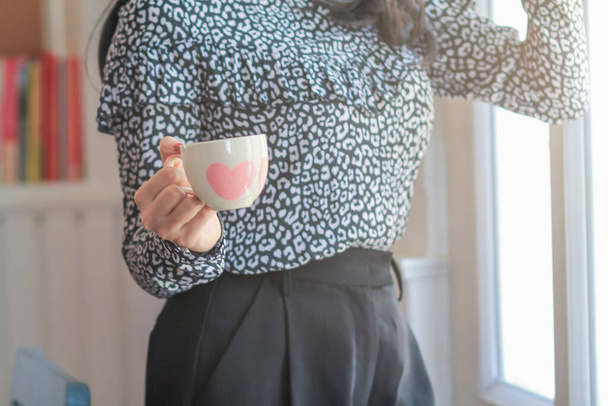 Immagini sfocate, Una donna d'affari sta tenendo una tazza di caffè per bere caffè caldo al mattino per prepararsi prima di iniziare a lavorare a casa.Stimolando te stesso per il lavoro al mattino bevendo caffè - Foto, immagini