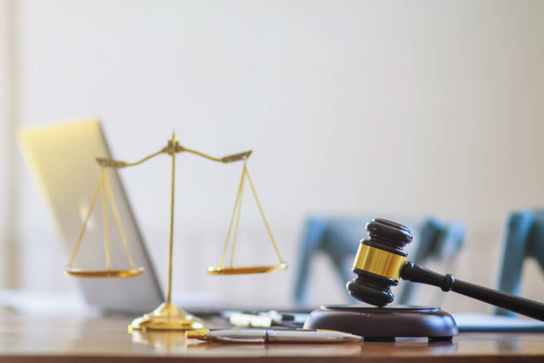 As escalas de martelo e latão são colocadas sobre a mesa no escritório do advogado para fins decorativos e são um símbolo de justiça em decisões judiciais.
. - Foto, Imagem