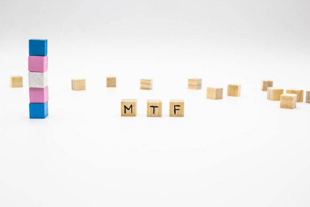 Letras MTF feitas de cubos de madeira e bandeira transgênero sobre fundo branco. Ilustração conceitual lésbica, gay, bissexual e transgênero
 - Foto, Imagem