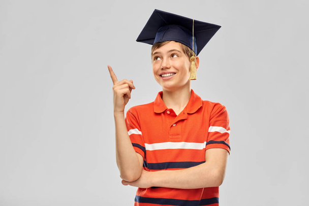 graduate student boy in mortarboard with finger up - Foto, afbeelding