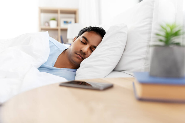 hombre indio durmiendo en la cama en casa
 - Foto, imagen
