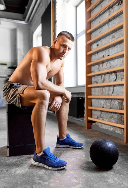 young man with medicine ball in gym - Фото, изображение