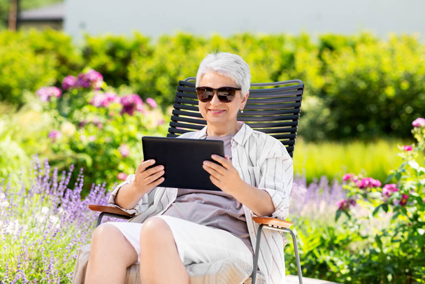 happy senior woman with tablet pc at summer garden - Photo, Image