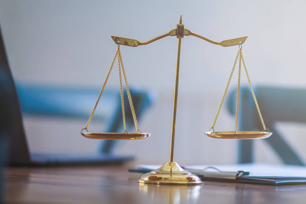 Латунные весы размещаются на столах в офисе адвоката для использования в качестве декораций и символа правосудия в судебном процессе. - Фото, изображение