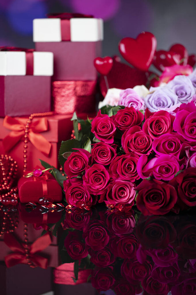 Wedding day concept. Big bouquet of roses and boxes with wedding gifts on glass table. - Photo, Image