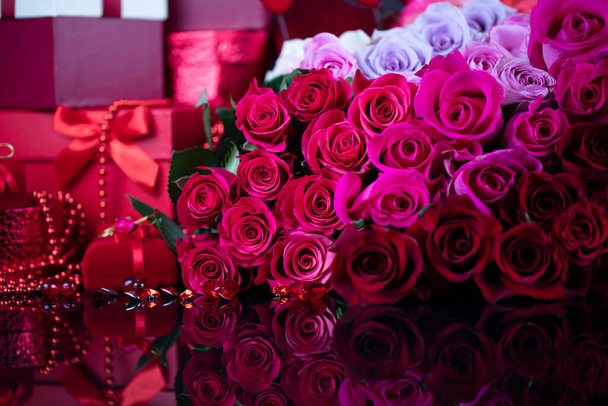 Concept de jour de mariage. Grand bouquet de roses et de boîtes avec cadeaux de mariage sur table en verre. - Photo, image