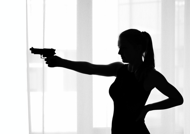 Silhouette of the girl with a gun - Photo, Image