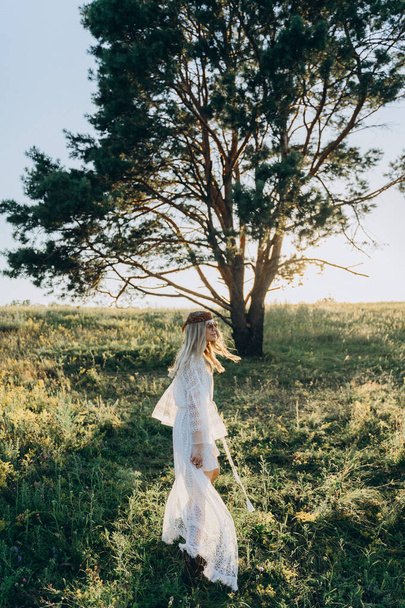 adult attractive woman in long white dress walking    in the field  - Valokuva, kuva