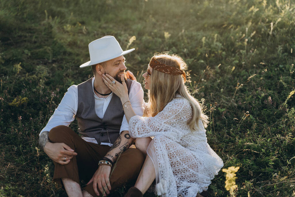 beautiful woman in white dress with handsome man  sitting on the lawn - Fotografie, Obrázek