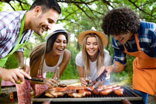 Group of friends having outdoor barbecue party and fun together - Foto, immagini