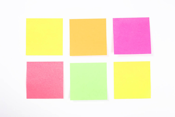 ομάδα κενών πολύχρωμων αυτοκόλλητων σημειώσεων χαρτιού που απομονώνονται στον λευκό τοίχο με χώρο αντιγραφής για το κείμενό σας - Φωτογραφία, εικόνα
