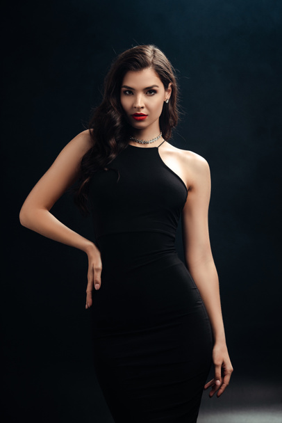 Beautiful woman with red lips looking at camera on black background - Foto, Imagen
