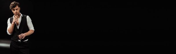 Панорамний знімок людини, що тримає келих віскі та сигари на чорному тлі
 - Фото, зображення