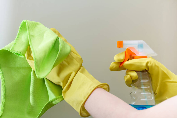 Toz bezi ve deterjanı olan eller camı temizliyor. - Fotoğraf, Görsel
