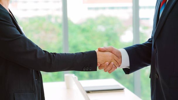 Biznesmeni uścisk dłoni w biurze korporacyjnym pokazując profesjonalne porozumienie w sprawie umowy finansowej. - Zdjęcie, obraz