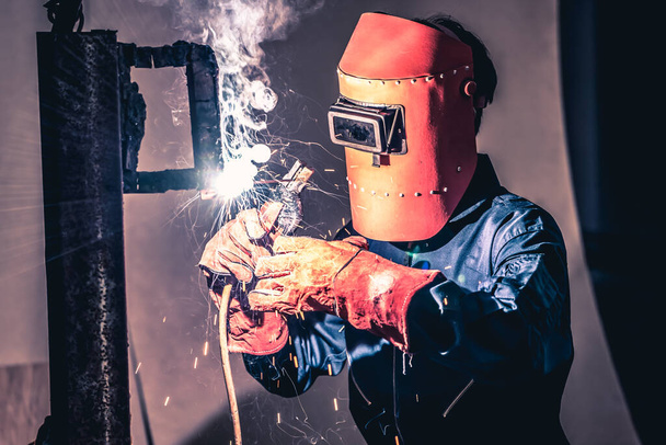 Metal welding steel works using electric arc welding machine to weld steel at factory. Metalwork manufacturing and construction maintenance service by manual skill labor concept. - Foto, afbeelding