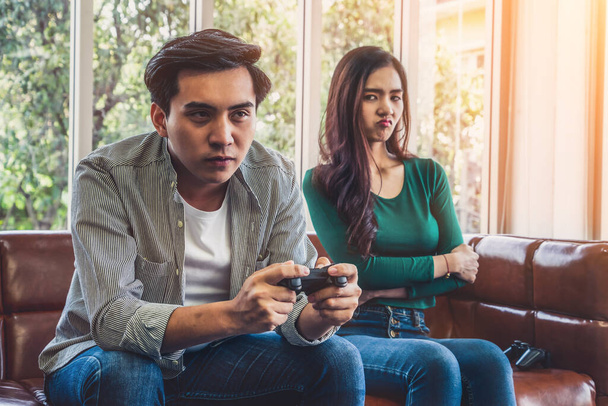 Joven pareja asiática sufre de adicción a los juegos de ordenador. Concepto de problema familiar
. - Foto, Imagen