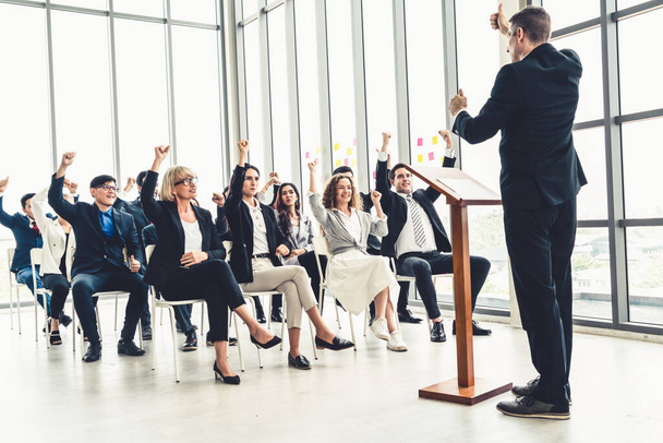 Group of business people meeting in a seminar conference . Audience listening to instructor in employee education training session . Office worker community summit forum with expert speaker . - 写真・画像
