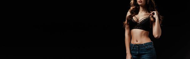 Панорамна орієнтація сексуальної жінки торкається бюстгальтера ізольовано на чорному
  - Фото, зображення
