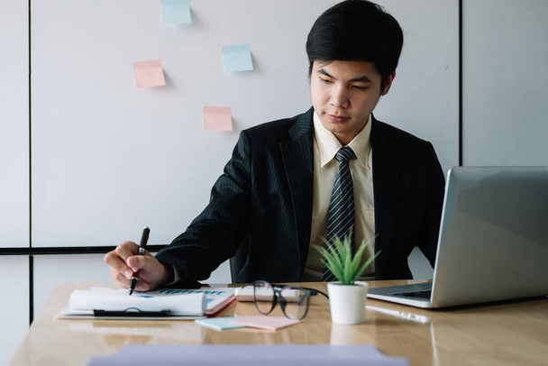 Asijský podnikatel pracující s notebookem pro finance v kanceláři - Fotografie, Obrázek