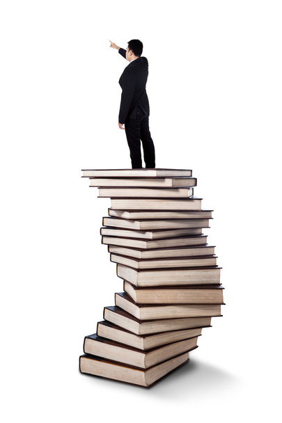 Uomo d'affari in piedi su un mucchio di libri
 - Foto, immagini