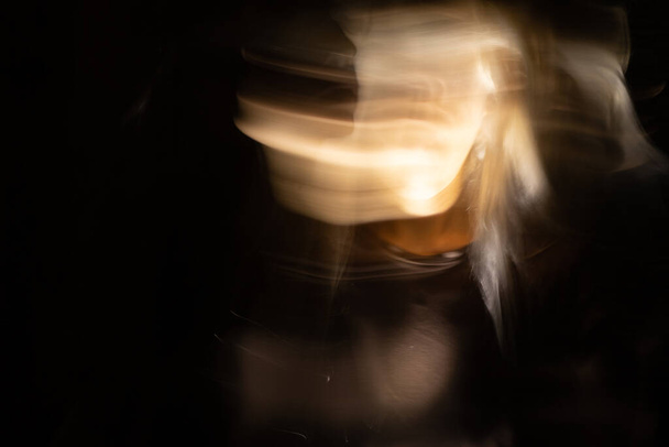Retrato abstracto emocional de una mujer gritando en la oscuridad con larga exposición, cara superpuesta, retrato de un miedo de chica
 - Foto, Imagen