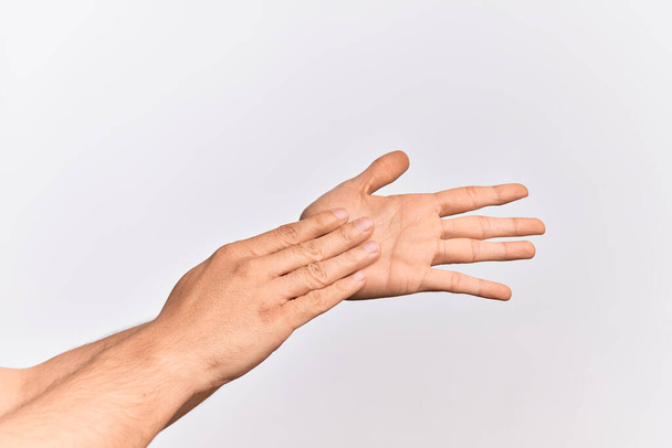 Χέρι του Καυκάσου νεαρός άνδρας δείχνει τα δάχτυλα πάνω από απομονωμένο λευκό φόντο αγγίζοντας παλάμες απαλή, λεπτή ομορφιά θέτουν - Φωτογραφία, εικόνα