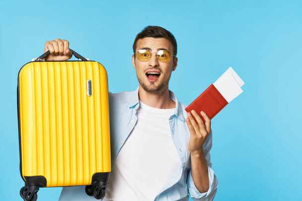 Паспорт и билеты на самолет Камера багажа Желтый чемодан пассажир в очках  - Фото, изображение