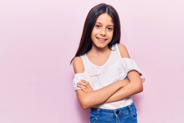 Beautiful child girl wearing casual clothes happy face smiling with crossed arms looking at the camera. positive person.  - Photo, Image