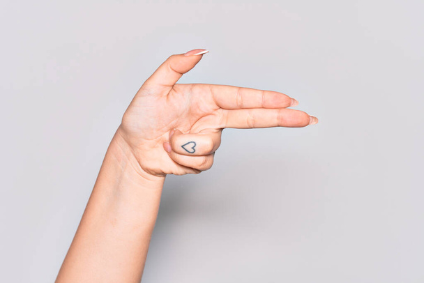 Hand einer jungen Frau aus Kaukasien gestikuliert mit den Fingern und zielt auf das Schusssymbol - Foto, Bild