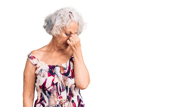 Senior mulher de cabelos grisalhos vestindo roupas casuais cansado esfregando nariz e olhos sentindo fadiga e dor de cabeça. conceito de estresse e frustração.  - Foto, Imagem