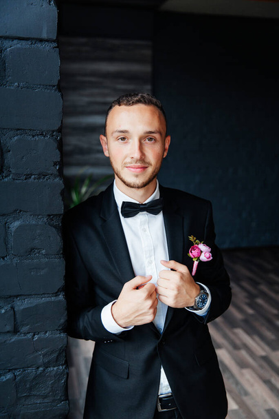 Portraits of the groom at the hotel training camp, dressed as a businessman in a black suit, tuxedo and white shirt - Photo, image