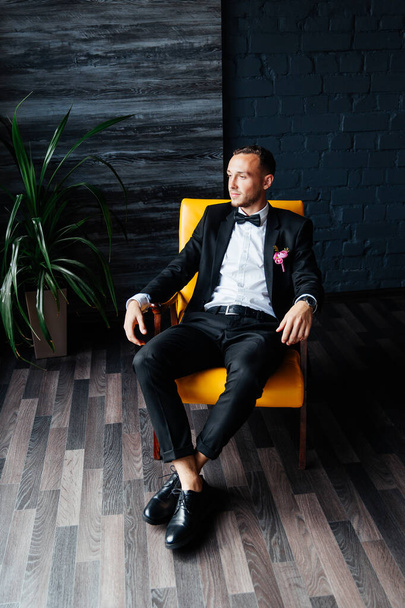 Portraits of the groom at the hotel training camp, dressed as a businessman in a black suit, tuxedo and white shirt - Foto, imagen