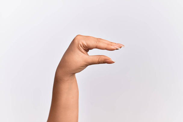 Рука кавказької молодої жінки, яка бере невидиму річ, тримає об'єкт пальцями, показуючи простір
 - Фото, зображення