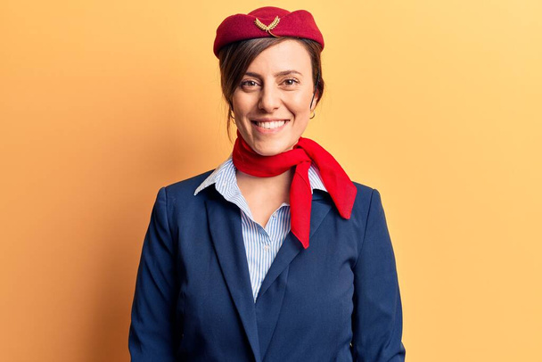 Молодая красивая женщина в униформе стюардессы со счастливой и прохладной улыбкой на лице. счастливчик.  - Фото, изображение