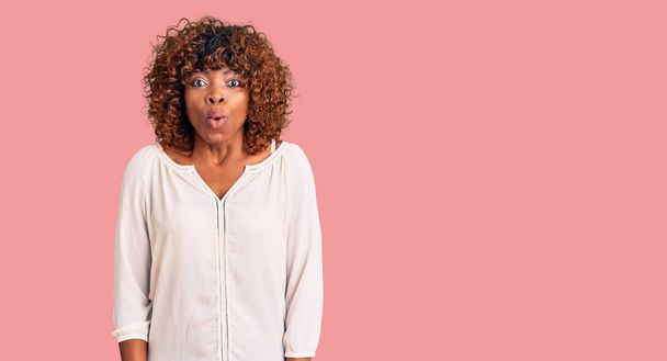 jonge Afrikaans amerikaanse vrouw dragen casual kleding bang en verbaasd met open mond voor verrassing, ongeloof gezicht  - Foto, afbeelding