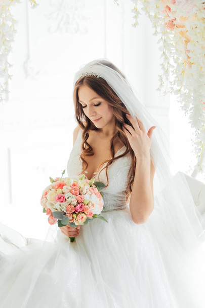 První setkání ženicha v černém obleku a nevěsty v bílých svatebních šatech s kyticí v interiéru fotoateliéru na bílém a černém pozadí - Fotografie, Obrázek